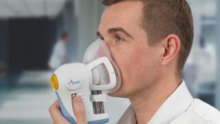 A man breathes into Owlstone Medical's ReCIVA Breath Sampler